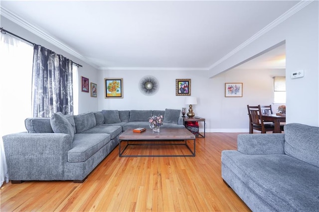 living room with baseboards, ornamental molding, and light wood finished floors
