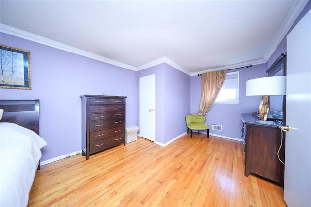 bedroom featuring visible vents, ornamental molding, light wood-style floors, and baseboards