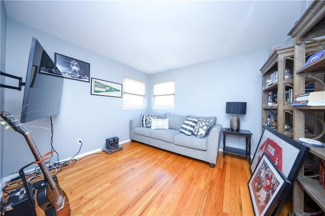 living area with baseboards and wood finished floors
