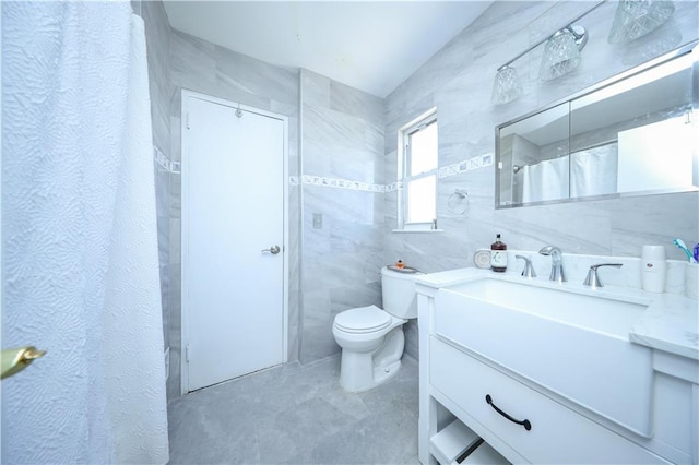 bathroom featuring toilet, tile walls, and vanity