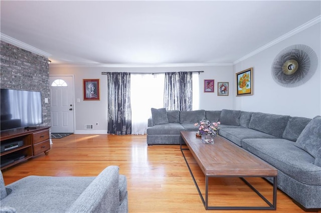 living room with crown molding, baseboards, visible vents, and light wood-style floors
