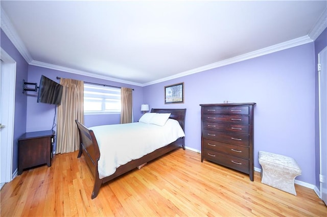 bedroom with baseboards, ornamental molding, and light wood finished floors