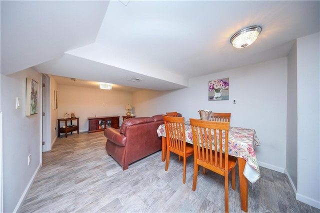 dining space featuring baseboards and light wood-style floors
