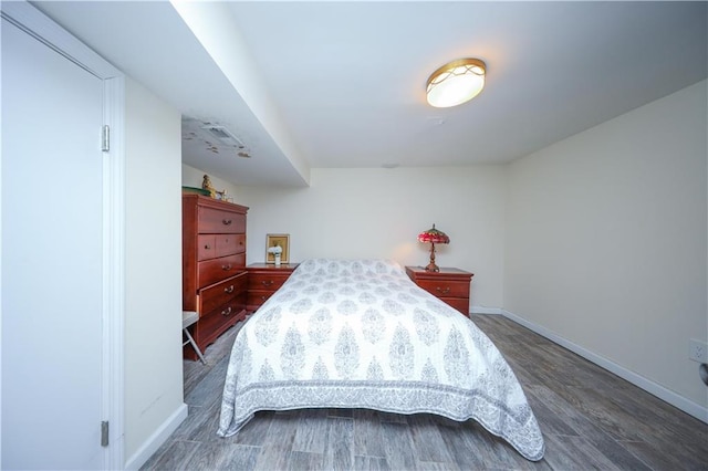 bedroom with baseboards and wood finished floors