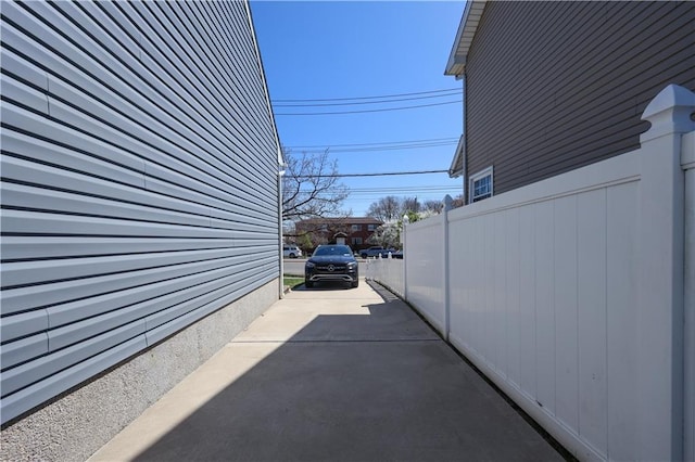 view of home's exterior with fence and driveway