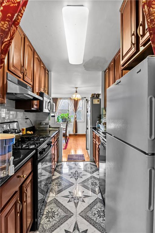 1655 Flatbush Ave Unit B204, Brooklyn, NY 11210 - kitchen with backsplash, dark countertops, freestanding refrigerator, black gas range, and under cabinet range hood