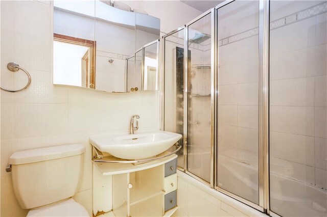 2944 W 5th St Unit 14F, Brooklyn, NY 11224 - full bath with toilet, a sink, tile walls, and tiled shower / bath combo