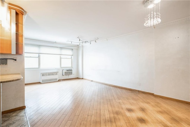 2944 W 5th St Unit 14F, Brooklyn, NY 11224 - unfurnished living room with radiator, baseboards, light wood-style floors, and a wall unit AC