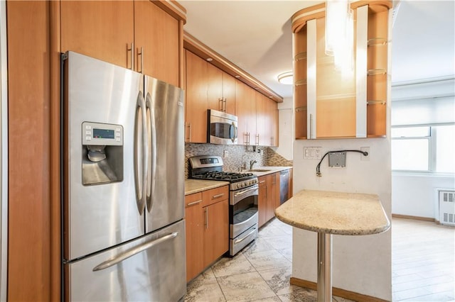 2944 W 5th St Unit 14F, Brooklyn, NY 11224 - kitchen featuring stainless steel appliances, backsplash, a sink, brown cabinets, and light stone countertops