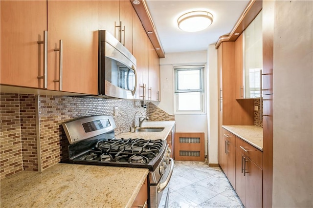 2944 W 5th St Unit 14F, Brooklyn, NY 11224 - kitchen with stainless steel appliances, tasteful backsplash, a sink, and light stone countertops