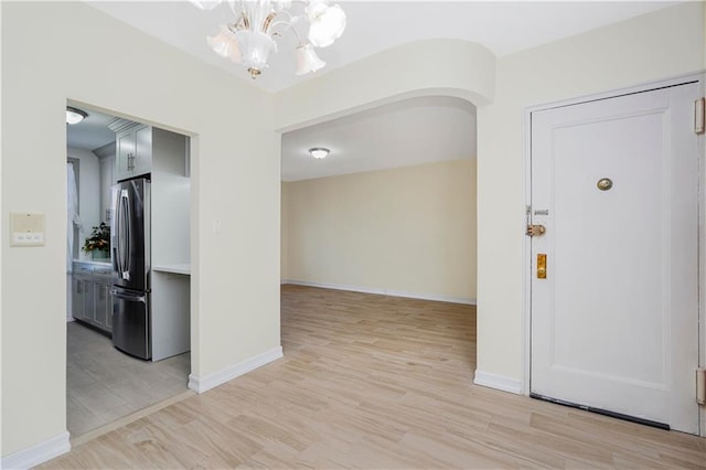2645 Homecrest Ave Unit 4C, Brooklyn, NY 11235 - entrance foyer featuring a chandelier, arched walkways, light wood finished floors, and baseboards