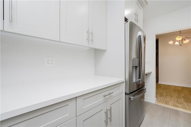2645 Homecrest Ave Unit 4C, Brooklyn, NY 11235 - kitchen featuring stainless steel fridge, light countertops, light wood-style floors, a chandelier, and white cabinets