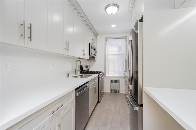 2645 Homecrest Ave Unit 4C, Brooklyn, NY 11235 - kitchen with appliances with stainless steel finishes, a sink, radiator, light countertops, and light wood-style flooring
