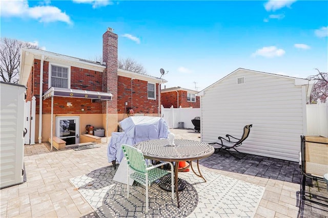 view of patio / terrace with a fenced backyard, an outdoor structure, and a shed