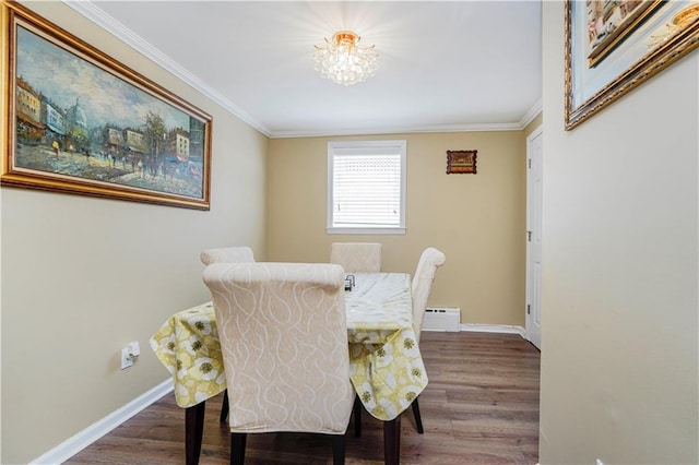 dining space with crown molding, a chandelier, baseboard heating, wood finished floors, and baseboards