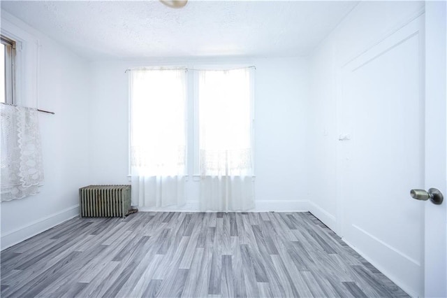 3029 Brighton 5th St Unit 3, Brooklyn, NY 11235 - unfurnished room featuring radiator, wood finished floors, and a textured ceiling