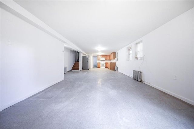 3029 Brighton 5th St Unit 3, Brooklyn, NY 11235 - unfurnished living room with radiator and stairway