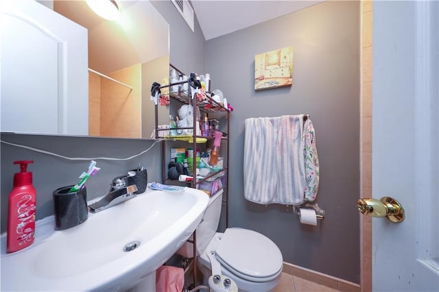 full bath featuring toilet, tile patterned flooring, and a sink