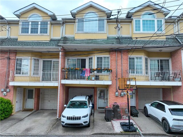 19 Ostrich Ct, Staten Island, NY 10309 - townhome / multi-family property featuring an attached garage, driveway, brick siding, and stucco siding