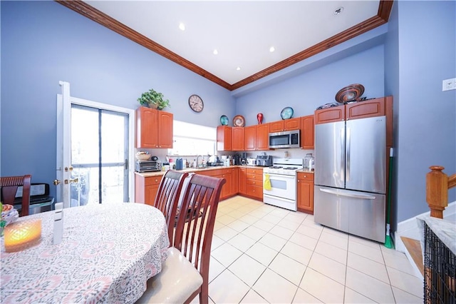 kitchen featuring a high ceiling, stainless steel appliances, light tile patterned floors, crown molding, and light countertops