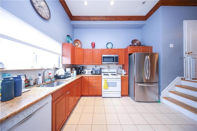kitchen featuring light tile patterned floors, stainless steel appliances, light countertops, a sink, and crown molding