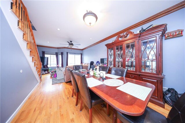 dining area with ornamental molding, ceiling fan, stairway, and light wood-style floors