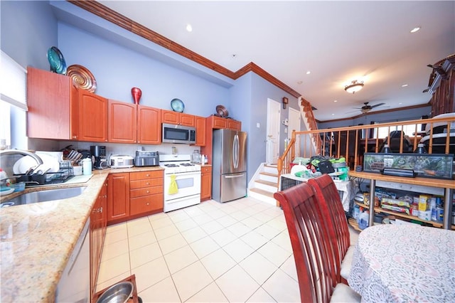 kitchen featuring crown molding, a sink, ceiling fan, stainless steel appliances, and light tile patterned flooring