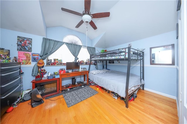 bedroom with baseboards, wood finished floors, a ceiling fan, and vaulted ceiling
