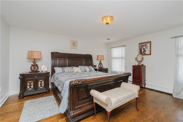 bedroom featuring a baseboard radiator, wood finished floors, and baseboards
