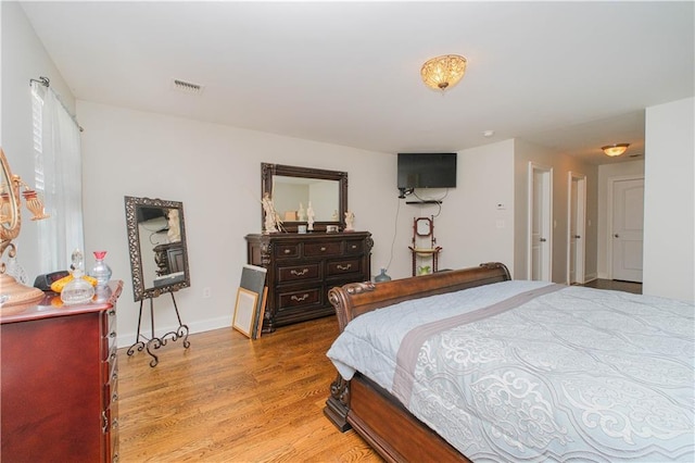 bedroom featuring visible vents, light wood-type flooring, and baseboards