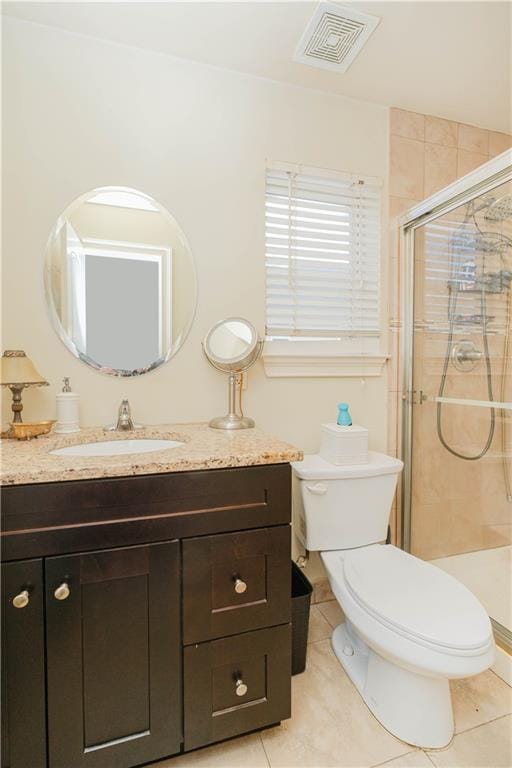 bathroom with visible vents, toilet, vanity, tile patterned floors, and a stall shower