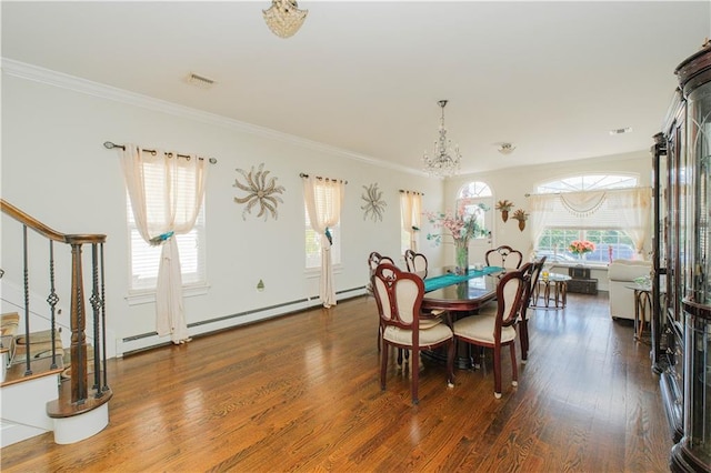 dining room with crown molding, wood finished floors, an inviting chandelier, and visible vents