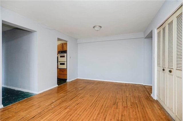 1580 E 13th St Unit 5C, Brooklyn, NY 11230 - unfurnished living room featuring baseboards and hardwood / wood-style floors
