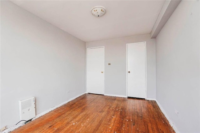 unfurnished bedroom featuring wood-type flooring and baseboards