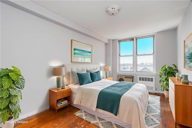 bedroom featuring radiator heating unit and hardwood / wood-style floors