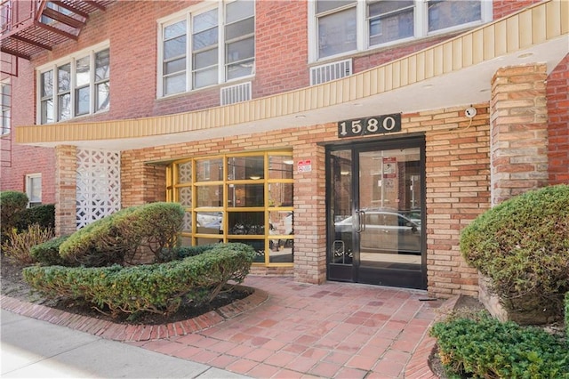 doorway to property featuring brick siding