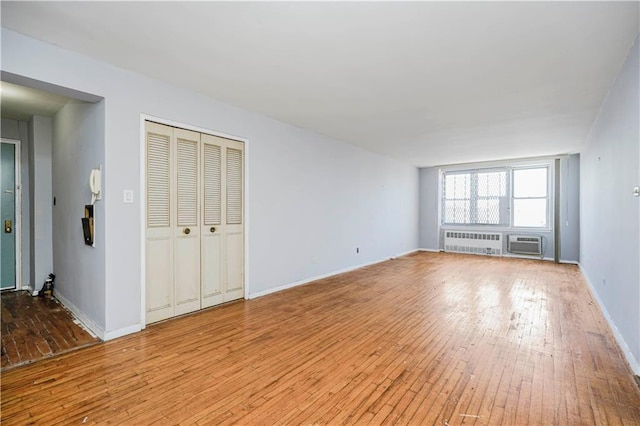 1580 E 13th St Unit 5C, Brooklyn, NY 11230 - unfurnished living room with wood-type flooring, baseboards, and a wall unit AC