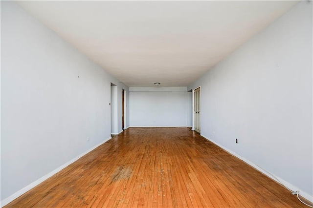 empty room featuring light wood-type flooring and baseboards