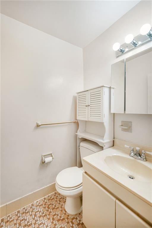 bathroom featuring vanity, baseboards, and toilet