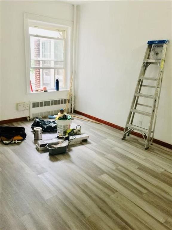 interior space featuring radiator, baseboards, and wood finished floors