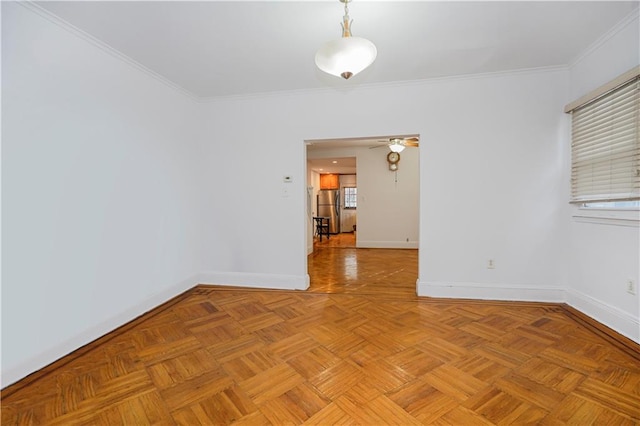 empty room with baseboards, ornamental molding, and a ceiling fan