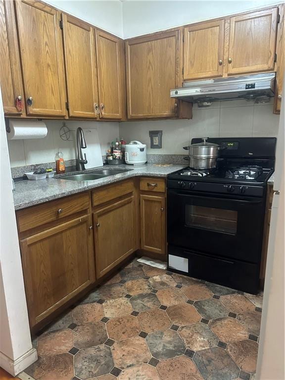 2878 W 16th St, Brooklyn, NY 11224 - kitchen with black range with gas stovetop, under cabinet range hood, and brown cabinets