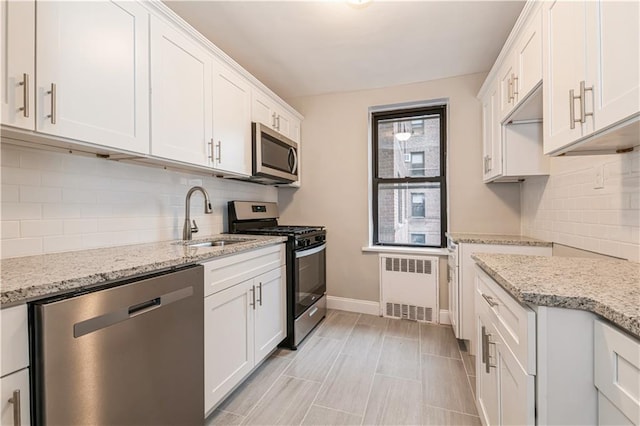 1119 Ocean Pkwy Unit 2A, Brooklyn, NY 11230 - kitchen with appliances with stainless steel finishes, radiator heating unit, a sink, and decorative backsplash