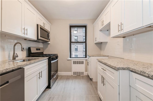 1119 Ocean Pkwy Unit 2A, Brooklyn, NY 11230 - kitchen featuring appliances with stainless steel finishes, radiator heating unit, a sink, and light stone countertops