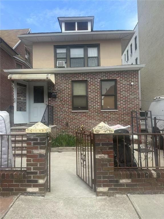 view of front of home featuring brick siding, fence, a gate, and stucco siding