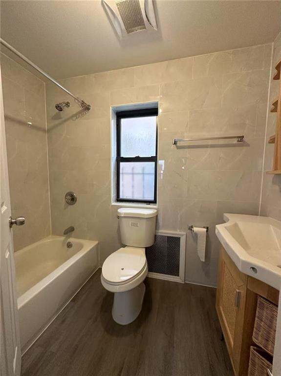 full bath featuring vanity, toilet, wood finished floors, and visible vents