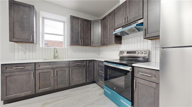 7902 16th Ave, Brooklyn, NY 11214 - kitchen with stainless steel electric range oven, freestanding refrigerator, a sink, under cabinet range hood, and backsplash