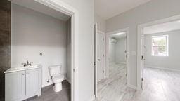 7902 16th Ave, Brooklyn, NY 11214 - bathroom with toilet, vanity, a shower, and baseboards