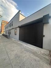 7902 16th Ave, Brooklyn, NY 11214 - view of side of property with driveway, stucco siding, and a garage