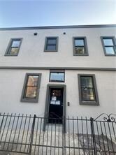 7902 16th Ave, Brooklyn, NY 11214 - view of front of home featuring stucco siding and a fenced front yard